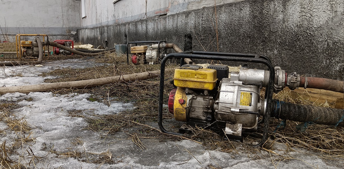 Откачка мотопомпами талой воды из подвала дома в Билибино